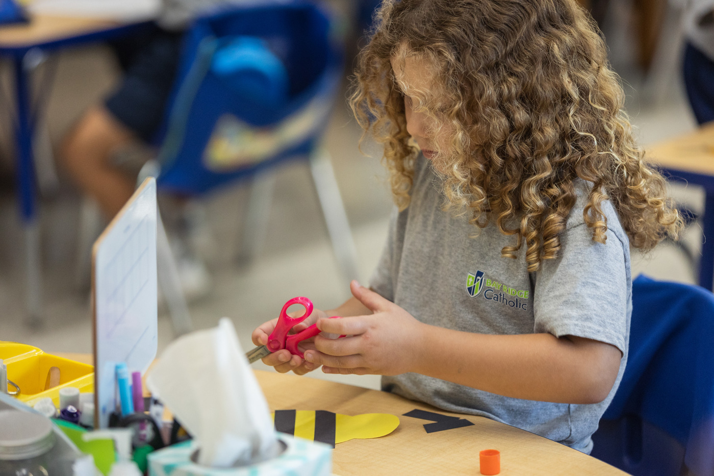 student working with scissors and construction paper